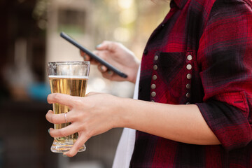 Happy Holidays Concept Male teenager playing smartphone with beer bottle
