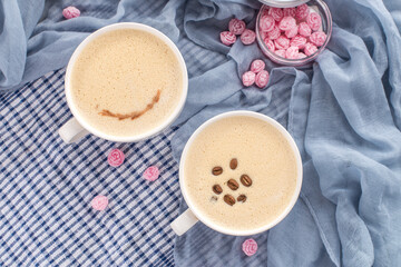 two transparent cups of coffee with milk on blue background