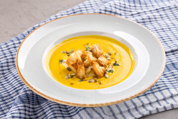 Homemade Autumn Butternut Squash Soup with Bread and seeds on the table