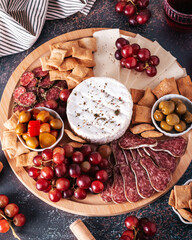 Mediterranean charcuterie board with various kinds of snacks for sharing on concrete background, top view