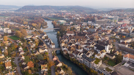 Fototapeta na wymiar Drone view of cityscape Brugg north-east with Aare river, residential and commercial districts, historic old town and casino bridge in canton Aargau in Switzerland. Town situated on feet of Tafeljura.