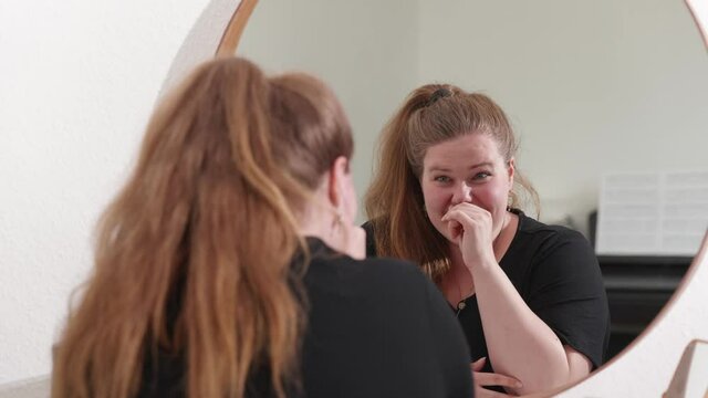 [4k] absorbed in thought plus size woman is having a gread idea while watching herself in the mirror at home