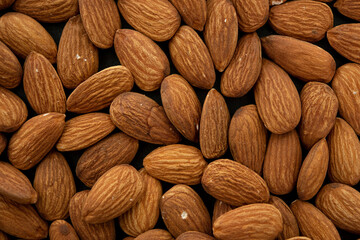 Background of big raw peeled almonds. Top view. Flat lay (selective focus; close-up shot)