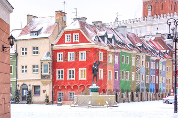 Merchants houses and fountain at Old Market Square in Old Town in the snowy winter day, Poznan, Poland