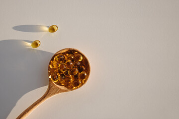 Capsules with vitamin D in wooden spoon