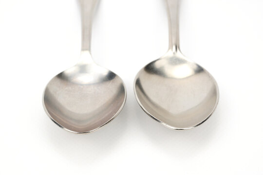Front view of two tablespoons lying upside down isolated on a white background