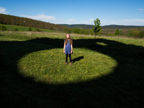 Girl standing in a field in the middle of a circle, Italy