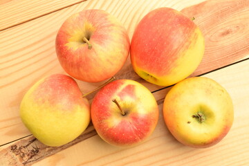Naklejka na ściany i meble Several ripe organic, juicy, aromatic apples, close-up, on a wooden table.