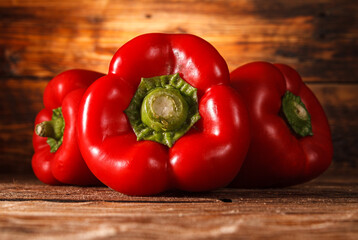 Red bell peppers on wooden background.