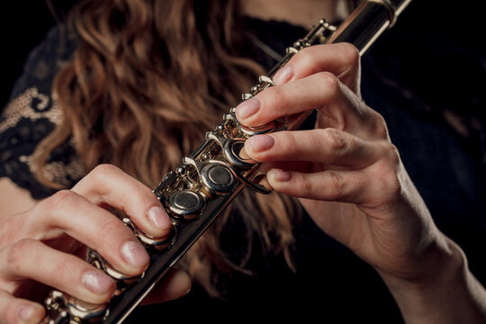 Close-up of the hands of a woman playing the flute. Musical concept.