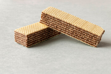 Several wafers with chocolate on a light background. Selective focus