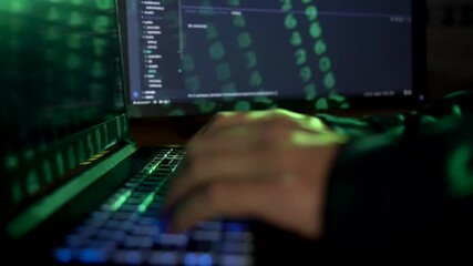 Closeup female hands is hacking password. Programmer software developer is typing malware virus on laptop keyboard to steal data. Binary code appears from projector light. Hacker attack concept. - Powered by Adobe