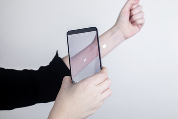 The woman shows his hand with a chip implanted which is read or scanned by a special device. Concept of chipping and implantation of electronic technologies. Cybernetics and the nanofuture. Cyberpunk