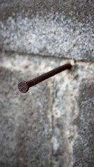 Clavo oxidado en muro de bloques de hormigón