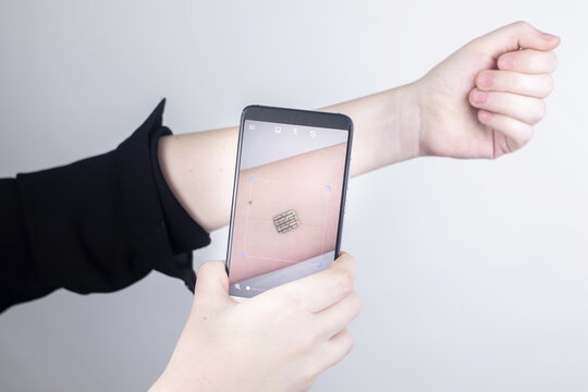 The woman shows his hand with a chip implanted which is read or scanned by a special device. Concept of chipping and implantation of electronic technologies. Cybernetics and the nanofuture. Cyberpunk