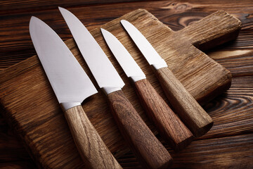 A variety of kitchen knives on a cutting board