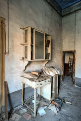 Fototapeta na wymiar November 2020, Italy. Old dentist's office of a country doctor, with a dental chair and lockers with medicines still in an abandoned house in Northern Italy. Urbex in Italy