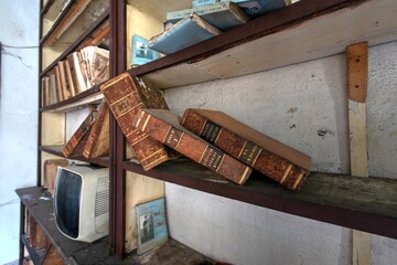 November 2020, Italy. Old books on a shelf of an abandoned dental office in Northern Italy. Urbex in Italy