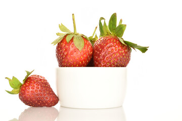 Several berries of bright red ripe organic tasty strawberries in a ceramic plate on a white background.
