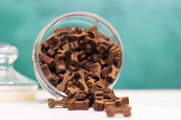 Dog treats spilling out of bowl. Dog treats and biscuits