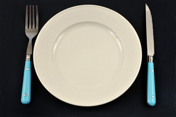 Assiette et couverts sur fond noir