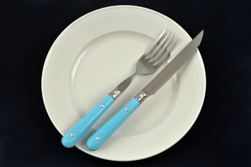 Assiette et couverts sur fond noir