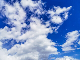 Naklejka na ściany i meble Bright blue sky with fluffy cumulus white clouds. Can be used as a design element, natural background.