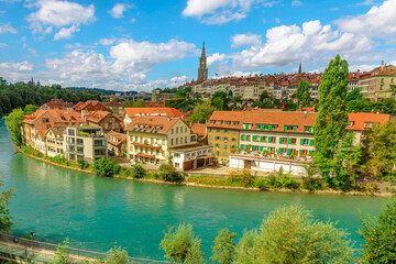 Aerial view of cityscape of old town of Bern, Switzerland, with Cathedral Bell Tower reflecting into Aare river. Popular landmark of historical town UNESCO World Heritage. Skyline of medieval houses.