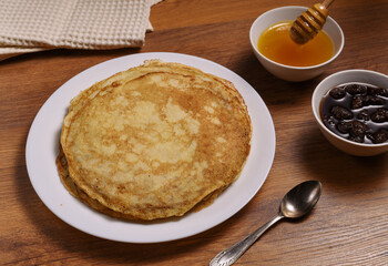 top view of pancakes on white dish and honey jar