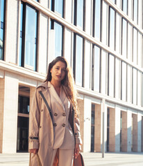 young pretty brunette woman in fashion suit at business building posing cheerful, lifestyle people concept