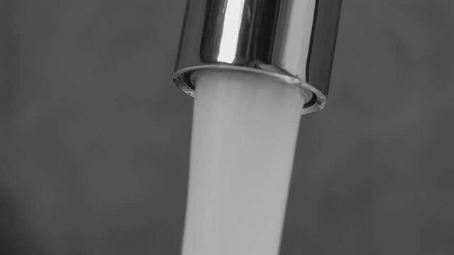 Water flows from the aerator of the tap of the water mixer. Drop formation. Drop of water drop. Close-up.
