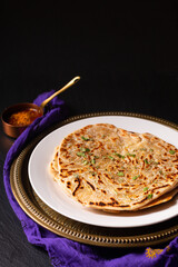 Food concept spot focus homemade Paratha, Parotta or Porotta layered flatbread  on black background with copy space