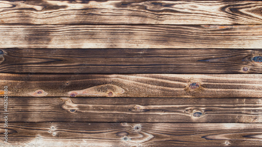 Poster wooden floor with traces of being burnt makes a black abstract background and texture.