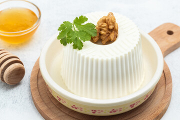 Still life of fresh cheese with honey on a white background