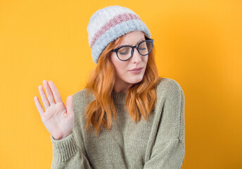Young woman gesturing stop sign with palm of hand,refuses or reject something, isolated on white...