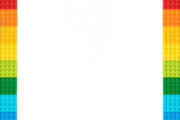 Frame of Multicolor Bricks constructor bricks on white background. Popular toys.