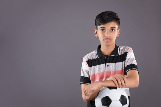 Smiling Indian Teen Boy Holding Soccer Ball Or Football	
