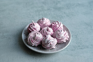 Home-made pink marshmallows lie on a plate. Gray background. 