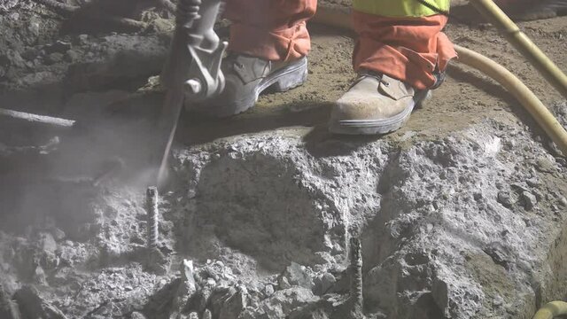 Jackhammer. Closeup. Road repair crew working at night under bright lights. 
