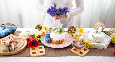 The process of decorating with flowers a festive Easter table with treats.