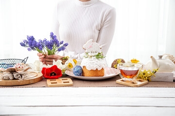 The process of decorating the festive table with flowers for the celebration of Easter.