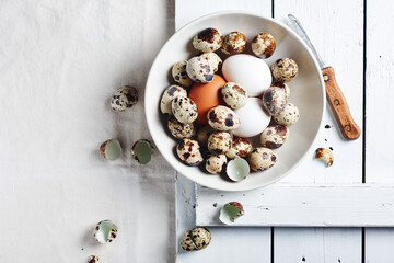 Quail and chicken eggs in a bowl.