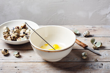 Broken quail eggs in a bowl.