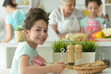 Cute happy girl eating  on  kitchen