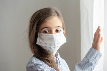 Little girl wearing a protective medical mask from coronavirus close up.