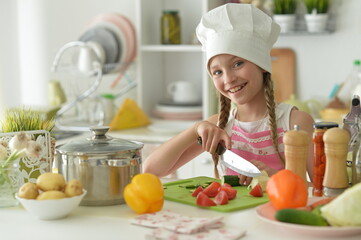 Cute happy girl coocking on  kitchen