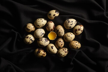 Quail eggs on a piece of black cloth. Close-up shot.