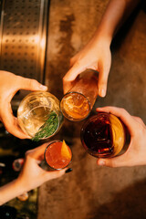 chears. four coctail in hands