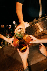 chears. four coctail in hands