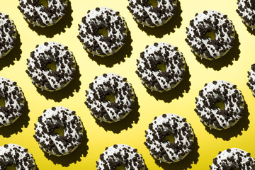 White donuts with black crumb on a yellow background